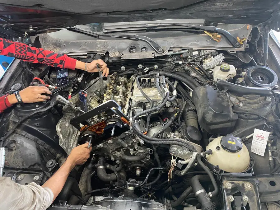 Mechaniker arbeiten gemeinsam im Motorraum eines Autos bei KFZ Service Gulben