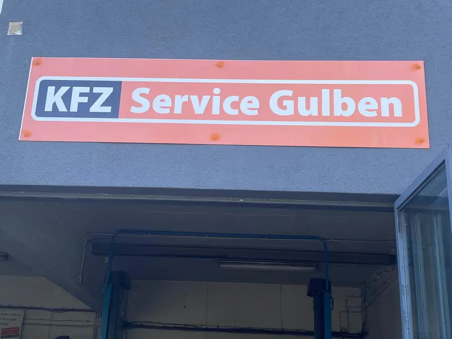 Schild mit KFZ Service Gulben über der Werkstatt