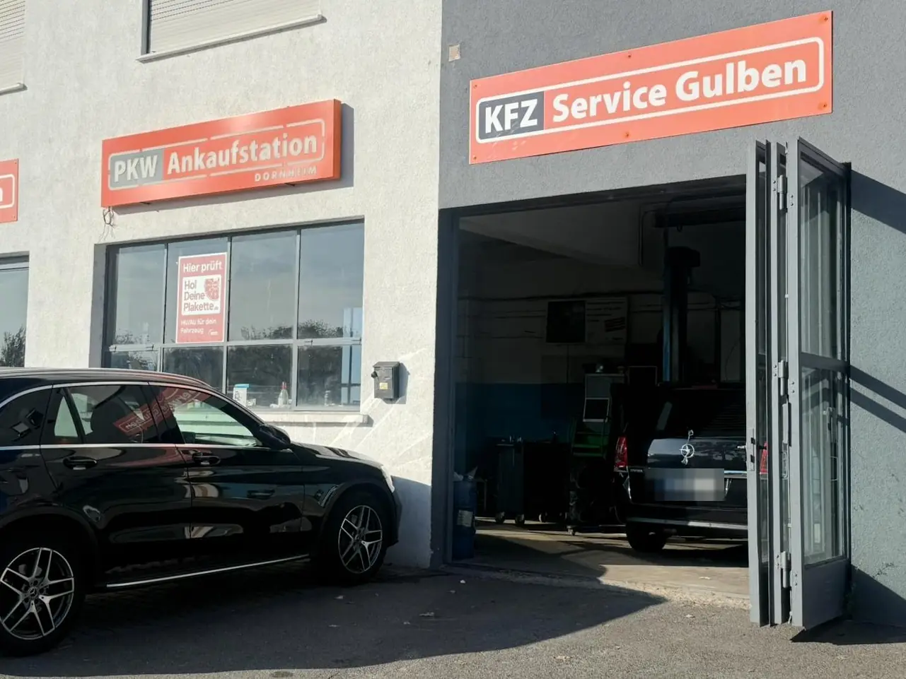 Werkstatt von KFZ Service Gulben mit geöffnetem Tor und Schild